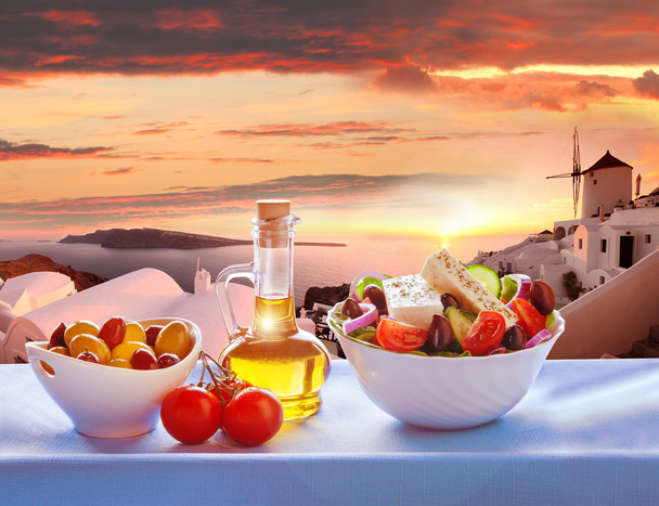 griechischer salat gegen windmühle in oia dorf, santorini insel in griechenland - Foto, Bild