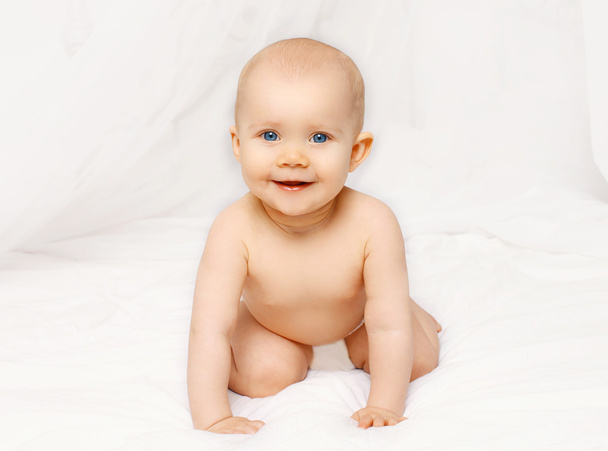 Portrait of smiling baby crawls on the bed at home - Foto, Imagem