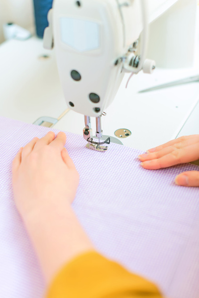 Vrouw handen bezig met naaimachine. - Foto, afbeelding