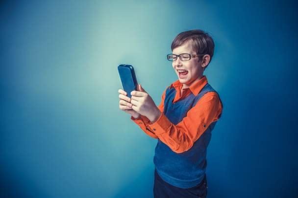 Menino de aparência europeia de dez anos em óculos segurando tablet
 - Foto, Imagem