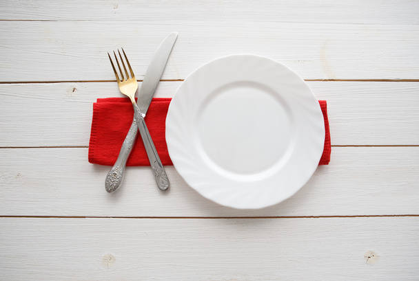 Knife, fork and dish over wooden table - Φωτογραφία, εικόνα