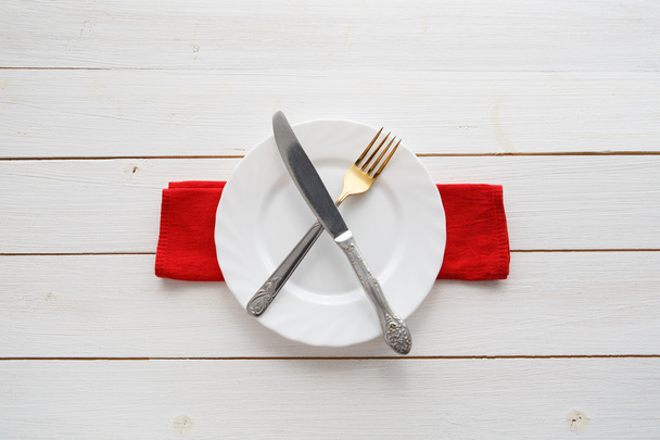 Knife, fork and dish over wooden table - Valokuva, kuva