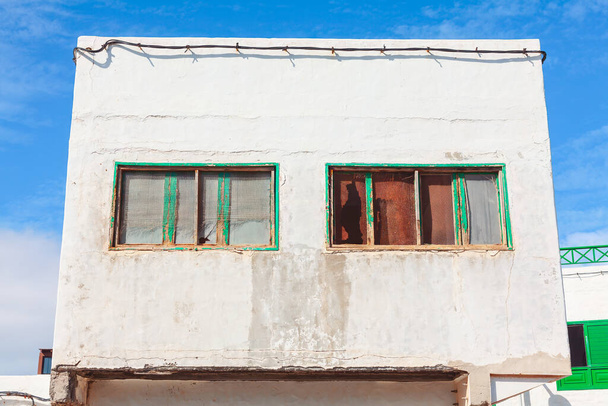 Zijaanzicht van het gebouw met groene ramen. Typische architectuur op de Canarische Eilanden - Foto, afbeelding