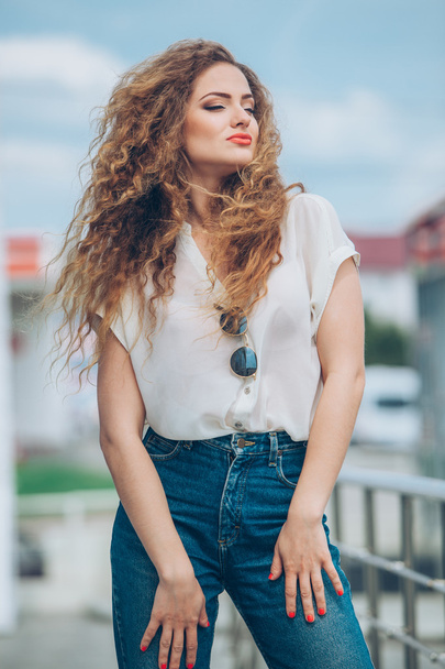 Beauty Girl Outdoors enjoying nature. Beautiful Teenage Model girl with long healthy blowing hair running in city, Sun Light. Glow Sun. Free Happy Woman.  In warm colors - Photo, image