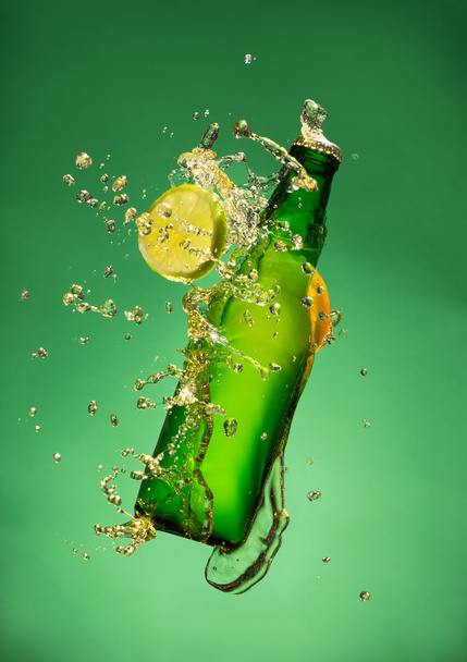 Bottle of fruit beer with splash, on gree - Foto, immagini