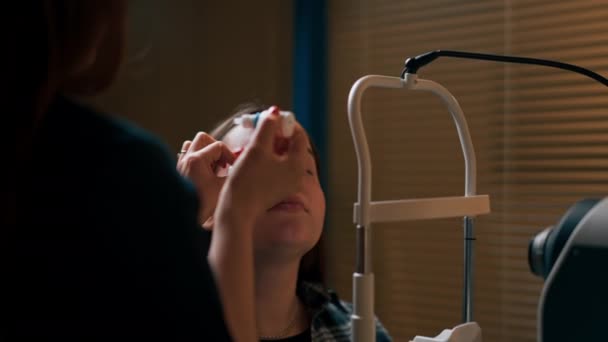 close-up em uma clínica de oftalmologia As gotas de congelamento são colocadas em um olho de meninas - Filmagem, Vídeo