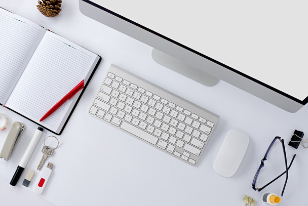 La mesa de oficina blanca con accesorios de papelería, teclado, ratón de ordenador
. - Foto, imagen