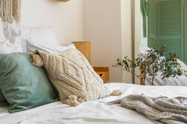 Подушки на удобной кровати в современной спальне, крупным планом - Фото, изображение