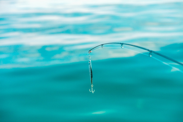 saltwater fishing - rod with wobbler and blue sea water - Фото, изображение
