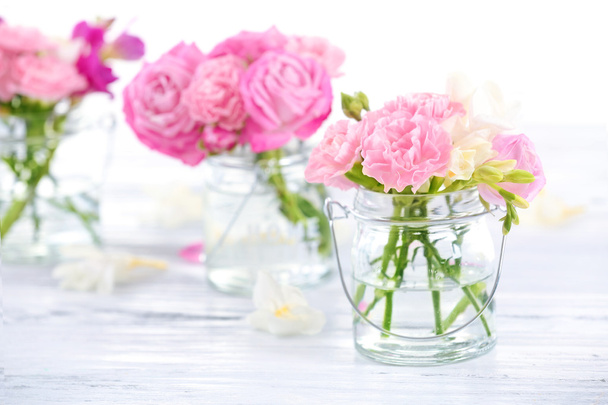 Beautiful spring flowers in glass bottles, closeup - Fotó, kép