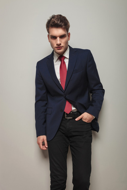 Young handsome business man leaning on a grey wall - Foto, immagini