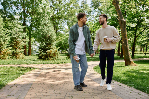 Een baard gay paar geniet van een ontspannen middag wandeling door een weelderig groen park, hand in hand, het delen van een glimlach en een moment van liefde. - Foto, afbeelding