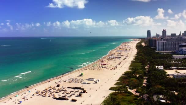 4k drón fooat. Lenyűgöző kilátás nyílik Miami Beach-re az érintetlen fehér homokkal, türkiz vizekkel. A partvonal tele van strandolókkal és toronyházakkal és üdülőhelyekkel.. - Felvétel, videó