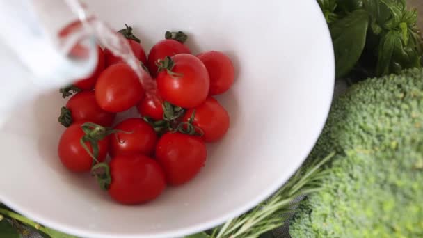 Kiraz domatesleri bir kasenin içinde ve suyla doludur. Yemek pişirme, sağlıklı beslenme - Video, Çekim