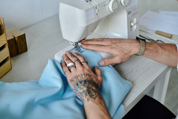 Молодий чоловік ретельно шиє одяг на швейній машинці, демонструючи свою прихильність до стійкості та відновлення старого одягу. - Фото, зображення