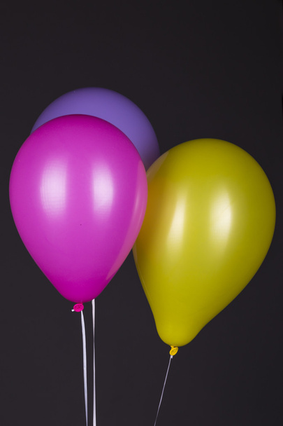 Värikkäitä ilmapalloja tummalla taustalla
 - Valokuva, kuva