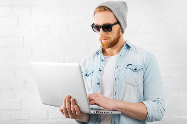 Bearded man holding laptop - Фото, изображение