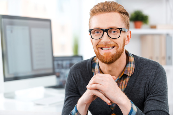 Bearded man in eyewear sitting at  working place - Photo, Image