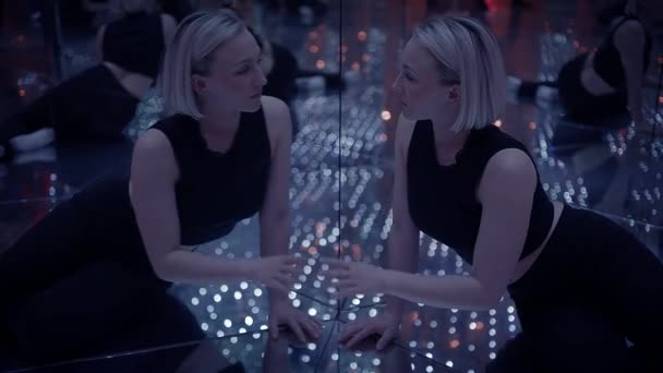 Jonge Blond vrouw verkennen kamer van spiegels in droomachtige fantasie neon licht - Video
