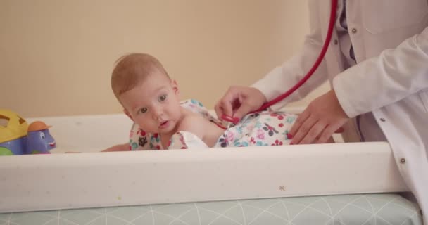 Ervaren pediatrische specialist onderzoekt baby 's ademhaling met behulp van stethoscoop. - Video