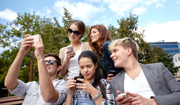 students or teenagers with smartphones at campus - Foto, imagen