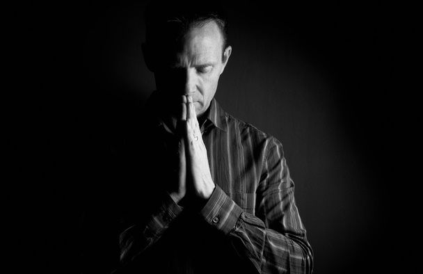 Ένας άνθρωπος προσεύχεται στο σκοτάδι - Φωτογραφία, εικόνα