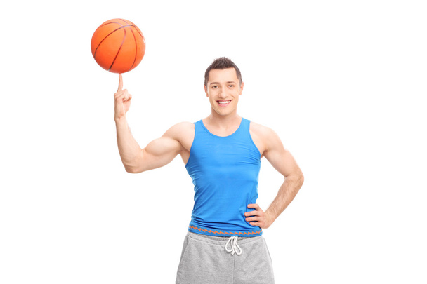 Cheerful sportsman spinning a basketball - Fotoğraf, Görsel