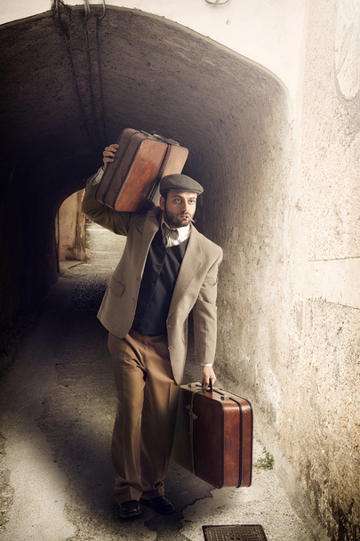 Emigrante homem com as malas em uma pequena cidade
 - Foto, Imagem