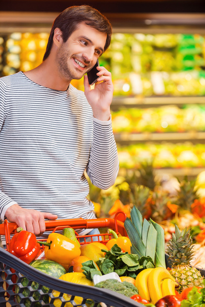 Man talking on mobile phone while shopping - Foto, Bild