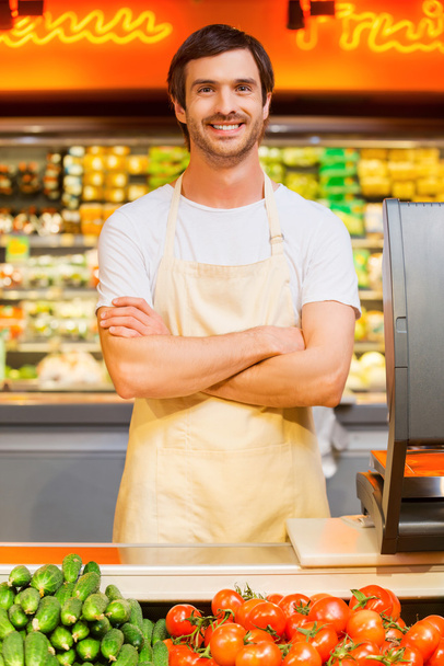Young cashier keeping arms crossed - Foto, Bild