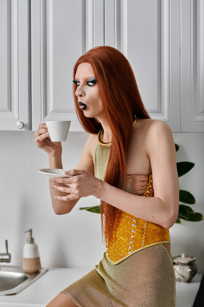 Eine Drag-Diva im glamourösen gelben Outfit genießt eine Tasse Kaffee in einer Küche. - Foto, Bild