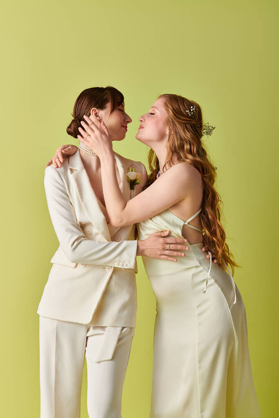 Egy fiatal leszbikus pár fehér ruhában osztozik egy gyengéd pillanaton az esküvői szertartás alatt.. - Fotó, kép