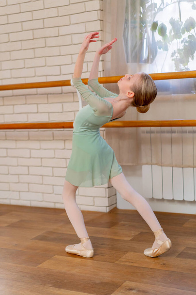 profesjonalna szkoła baletowa dla dzieci solowa próba tańca dziewczynki w jasnozielonym body - Zdjęcie, obraz