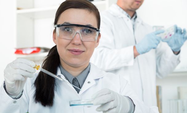 жінка-дослідник зі скляним обладнанням в лабораторії
 - Фото, зображення
