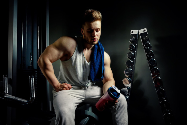 erős testépítő sportoló fehérjék rázógépen és törölköző - Fotó, kép