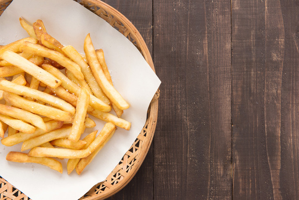 Traditional french fries in basket on wooden background. - Foto, Imagen