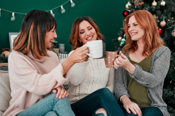 Coffee, cheers and women on couch with smile for celebration, holidays and reunion in home. Friends, Christmas and together in living room for vacation, connection and toast with tea in apartment. - Photo, Image