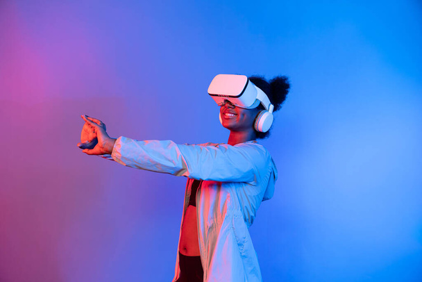 Giovane donna africana giocare nel giocatore di basket indossando VR posa rimbalzante isolato luce blu al neon che collega la tecnologia digitale futuristica realtà virtuale a metaverso corte mondiale. Congegno. - Foto, immagini