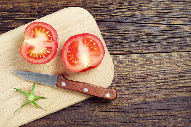Dos rebanadas de tomate en la tabla de cortar
 - Foto, Imagen