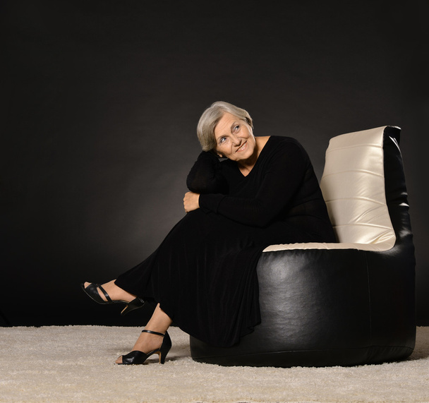 Elderly woman sitting on  armchair - Valokuva, kuva