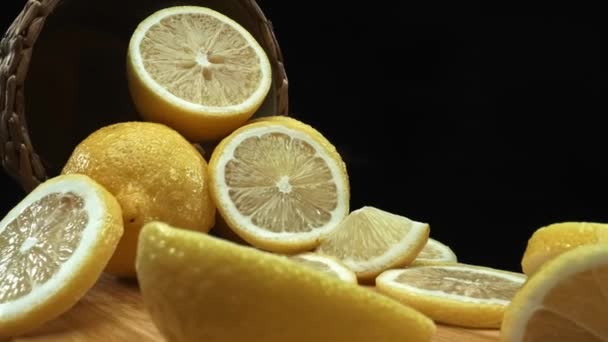 Detailní záběr na plátky citronu jsou pečlivě uspořádány na pozadí rustikálního koše na hlubokém černém povrchu. Každý plátek, zalitý měkkým světlem na tmavém pozadí, Makrografie. Poživatelné. - Záběry, video