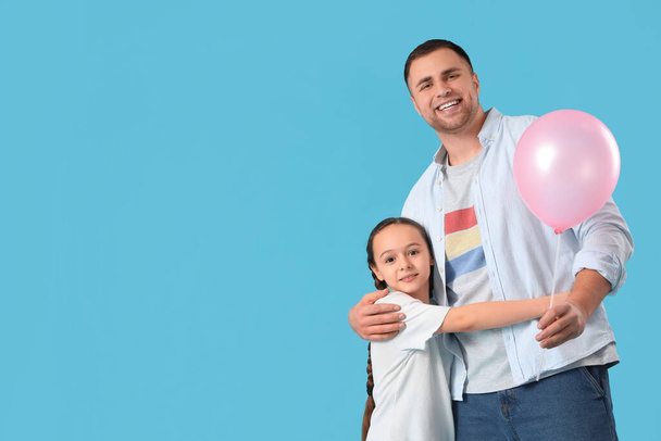 Father and his daughter with balloon on blue background - Photo, Image