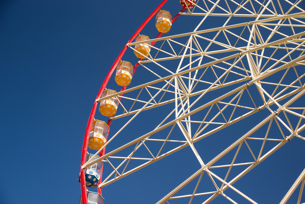 Atraktsion Ferris rueda contra el cielo azul
 - Foto, Imagen