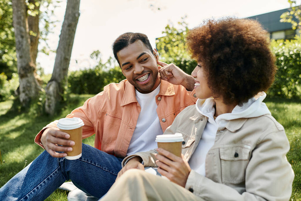 Onnellinen afroamerikkalainen pari nauttii aurinkoisesta päivästä ulkona, käyttäen viittomakieltä kommunikoimaan. - Valokuva, kuva