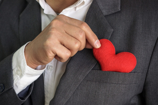 Businessman holds red heart - Foto, afbeelding