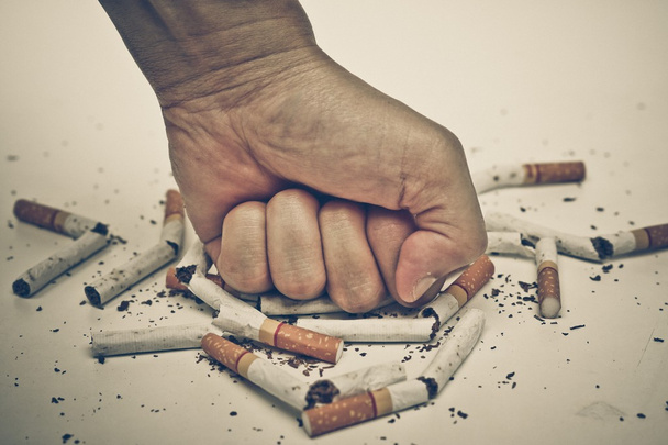 Mano masculina destruyendo cigarrillos
 - Foto, Imagen