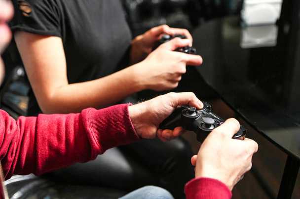Un homme et une femme sont activement engagés dans un jeu vidéo ensemble, en compétition les uns contre les autres. - Photo, image