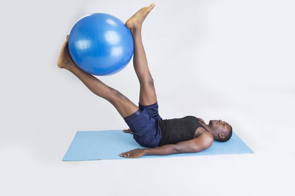 young sportsman does fitness with baloon and on carpet - Photo, Image