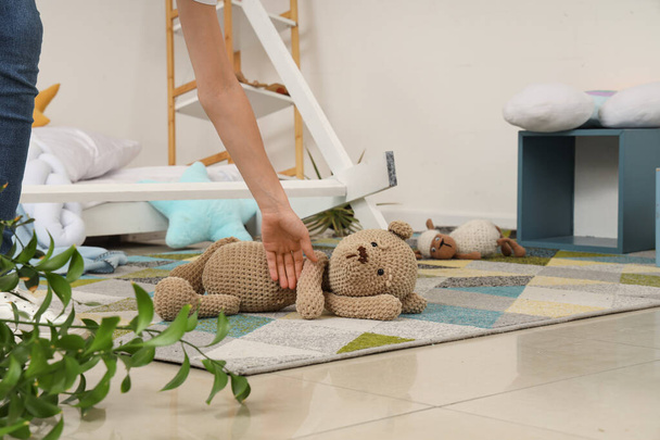Mujer tomando oso de juguete del suelo después del terremoto en la habitación de los niños - Foto, Imagen