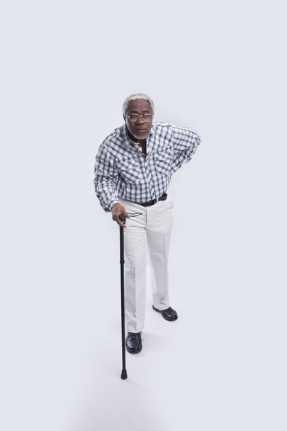 Aged man walks with cane - Фото, зображення